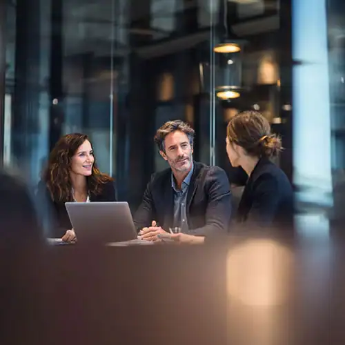 A man and two women in a business meeting